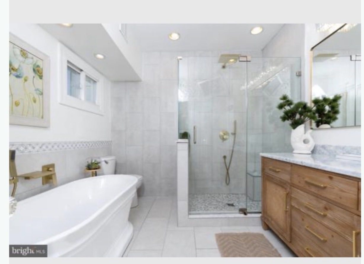 Bathroom after renovation with frameless glass shower and freestanding soaking tub
